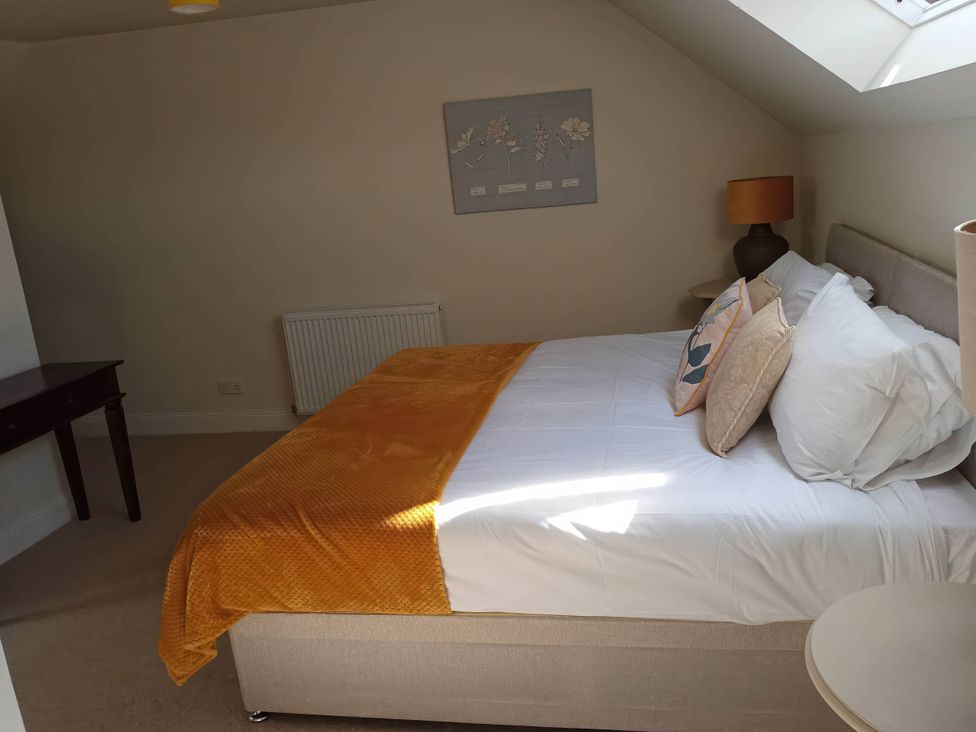 A bedroom with a bed and a lamp at The Old Barn in Manchester
