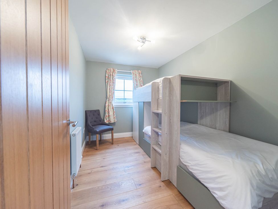 A bedroom with a bunk bed and chair at the property in location