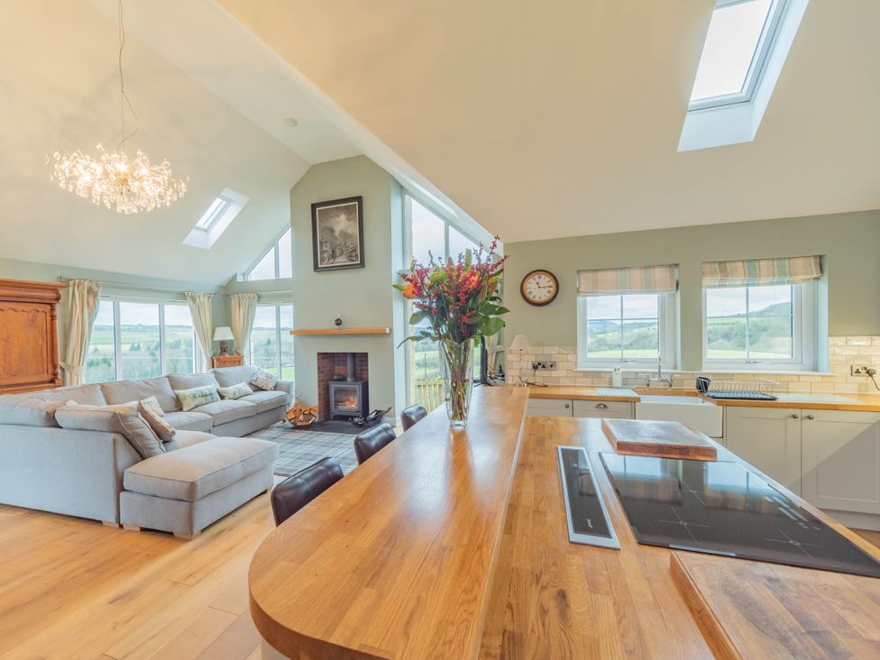 A living room with a sofa and a kitchen counter at a home in a rural area