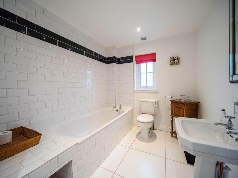 A bathroom with a bathtub, toilet, and sink at the property in location