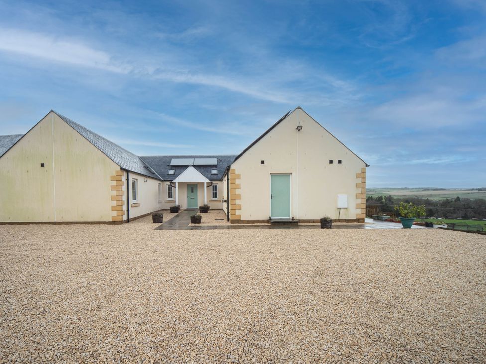 An outdoor view of a house with a gravel area at the property in 