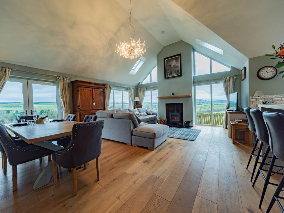 A living room with a sofa and dining area at the property in a scenic location