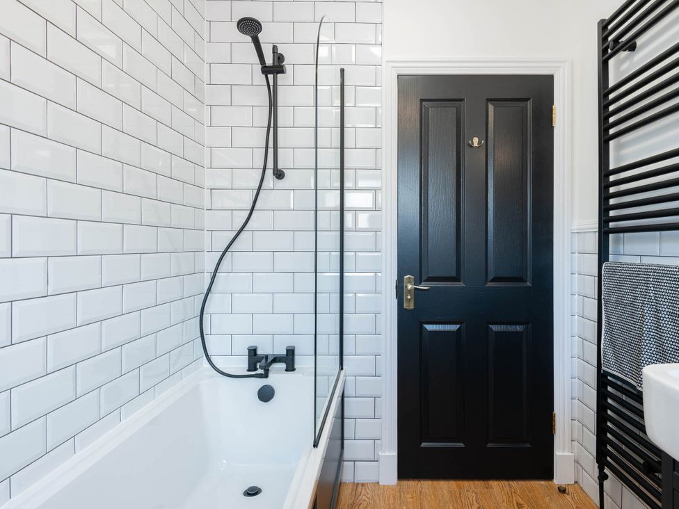 A bathroom with a bathtub, shower, and towel radiator at 