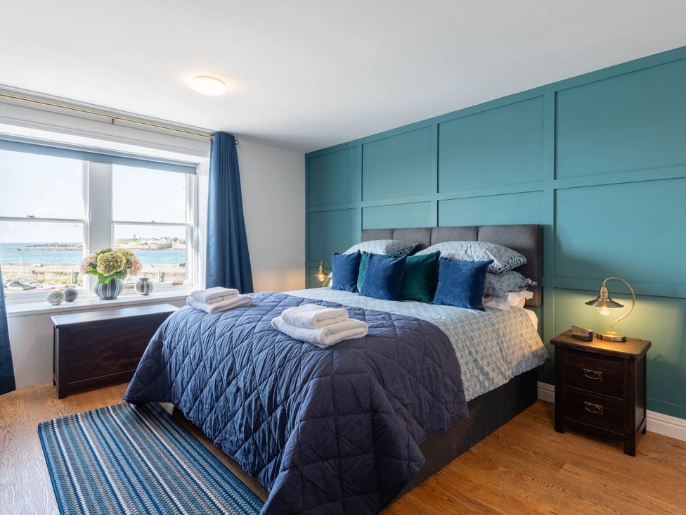 A bedroom with a large bed and ocean view at the coastal property in unspecified location