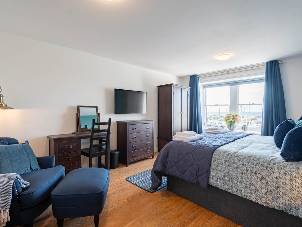 A bedroom with a bed, television, and desk at a property