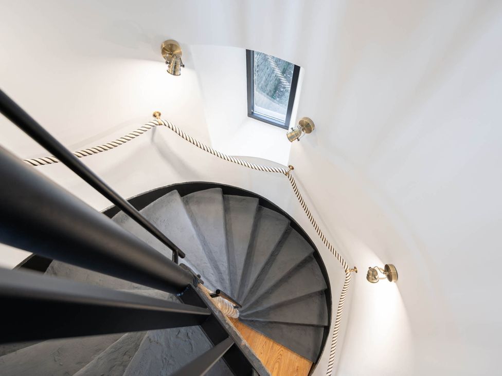 A staircase with a spiral design and light fixtures at 