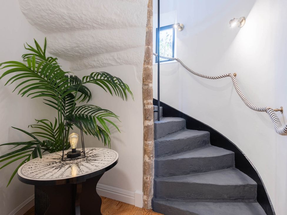 A staircase with a plant and table at a property