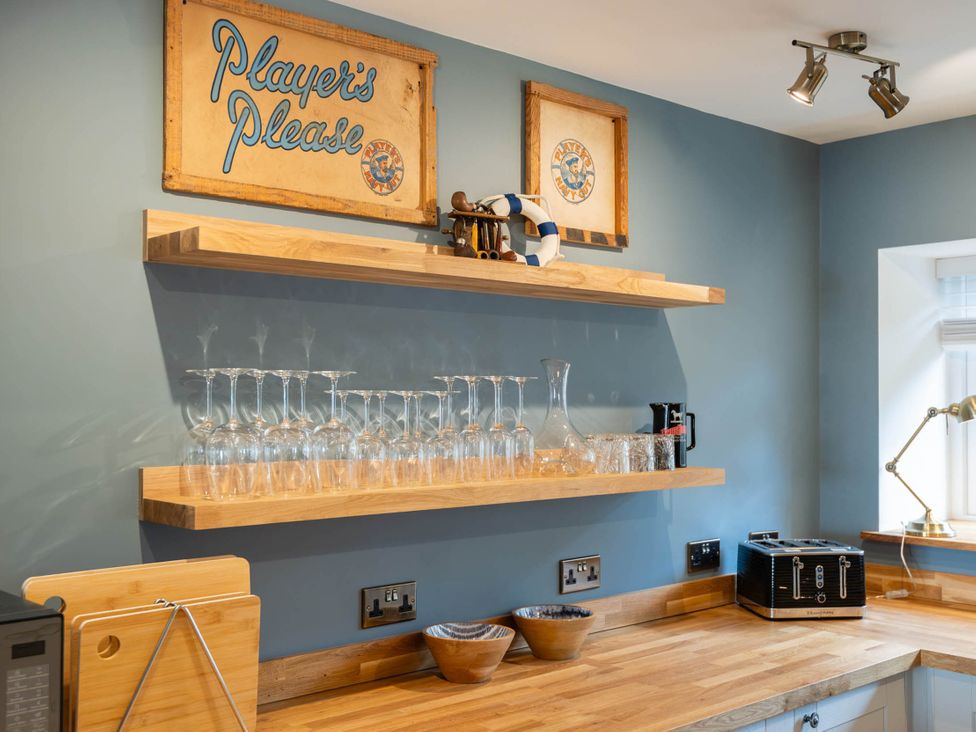 A kitchen with glassware on shelves and a sign at 