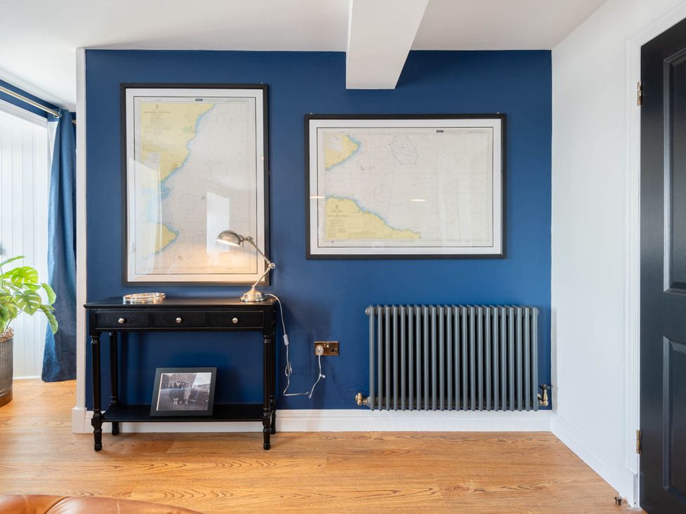 An office with a desk, maps on wall, lamp, and radiator at 