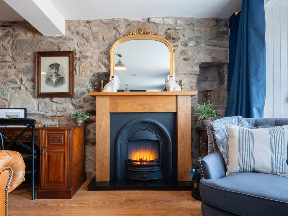 A living room with a fireplace and a mirror at The Old Barn in Manchester