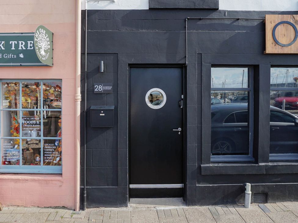 A storefront with a black door and a window display at 28 Shorefront in an unknown location