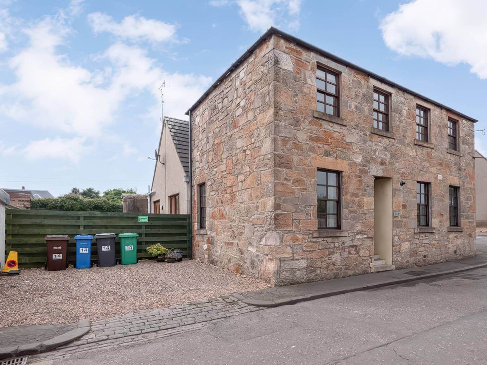 A house with garbage bins and a pathway near a street