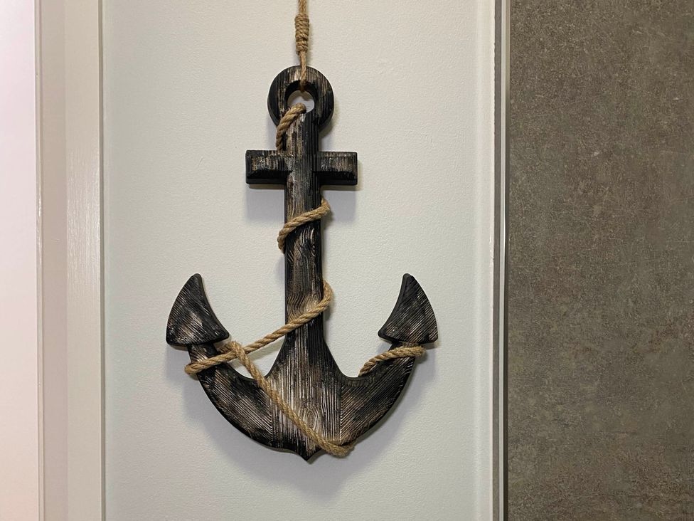 A decorative anchor with rope on a wall at a property