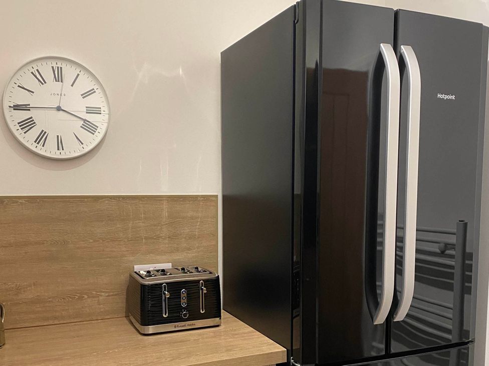 A refrigerator and a toaster on a countertop in a kitchen