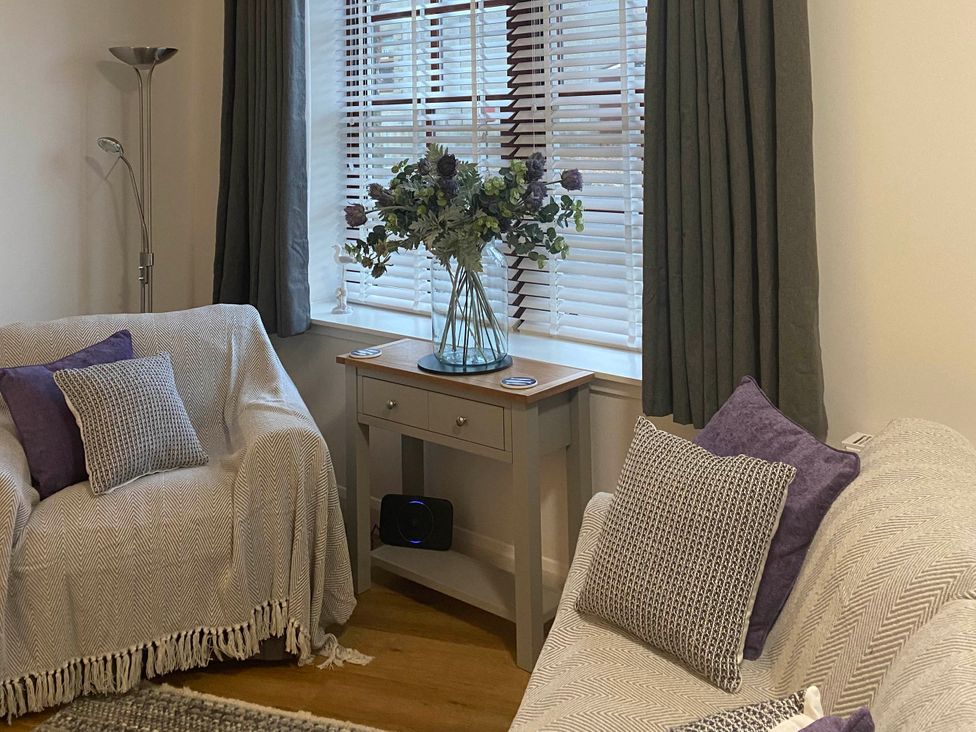 A living room with two sofas and a table with flowers at The Old Barn in Manchester