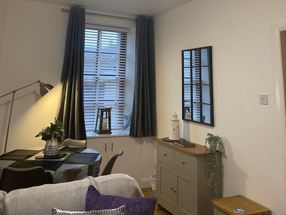 A living room with a window and table at The Old Barn in Manchester