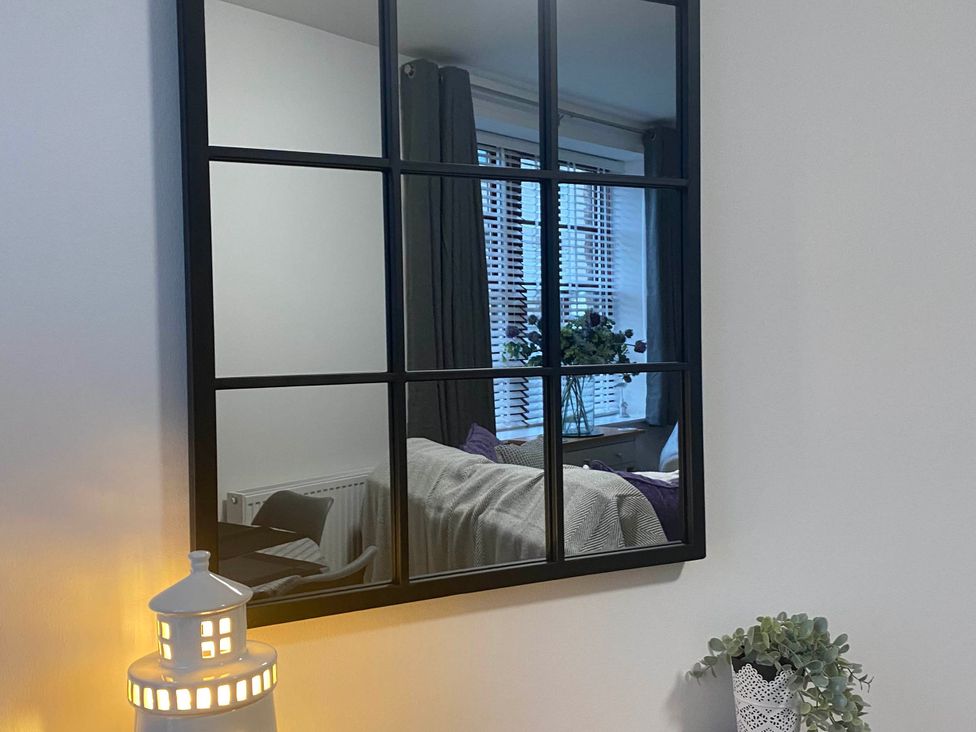 A living room with a mirror and a lamp at an unspecified location