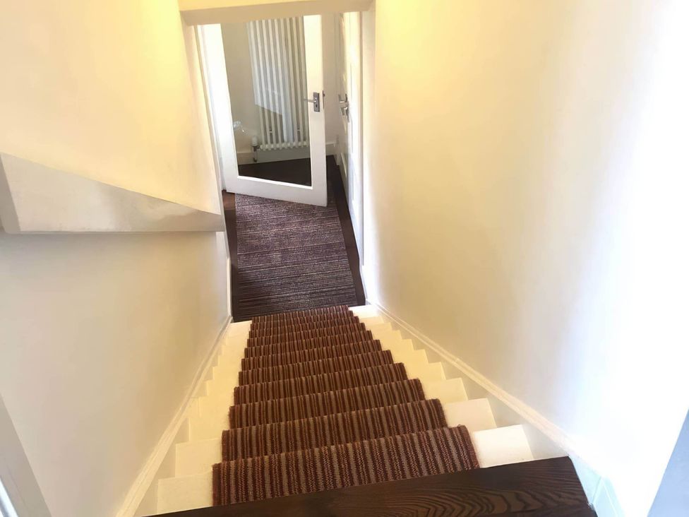 A staircase with a door and rug at a property