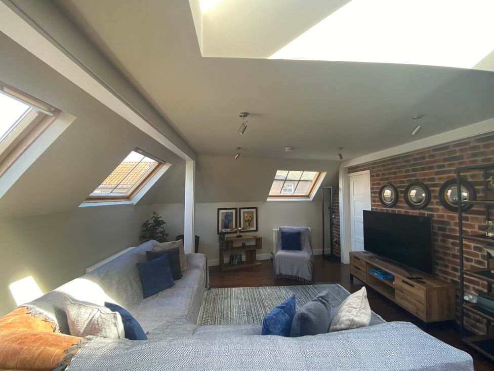A living room with a sofa and television at The Old Barn in Manchester