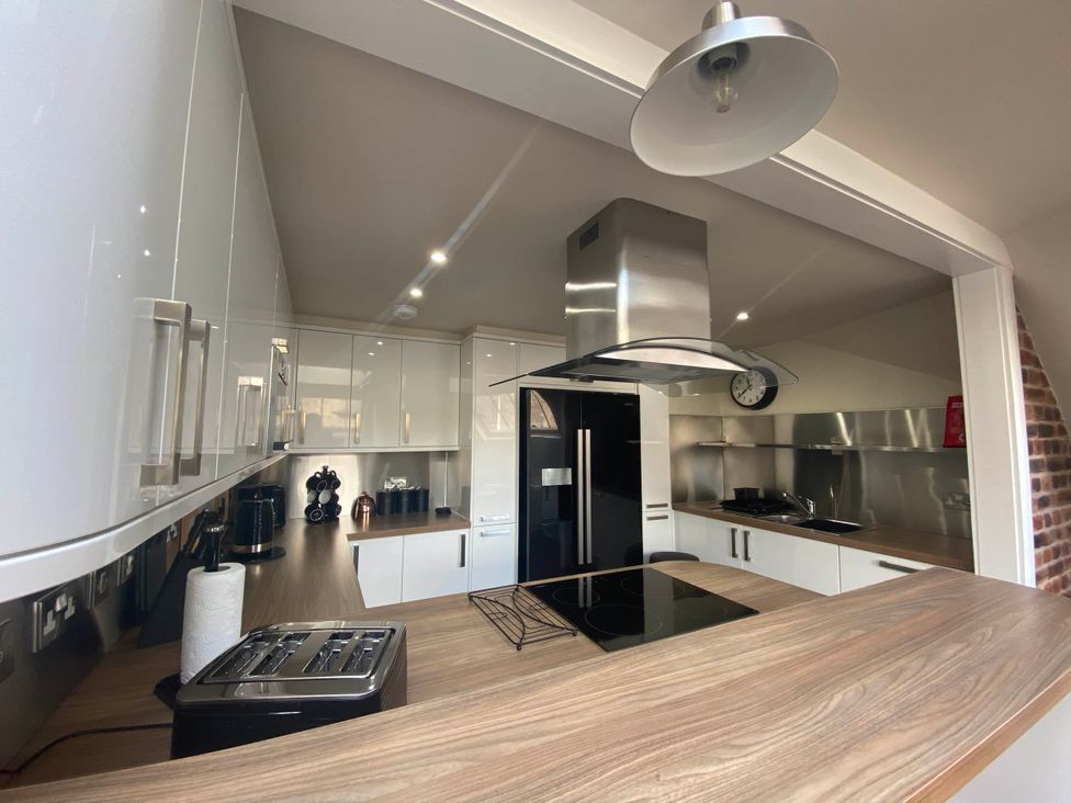 A kitchen with modern appliances and wooden countertop at The Old Barn in Manchester