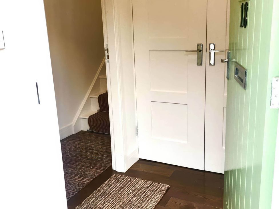 A hallway with doors and a staircase at The Old Barn in Manchester