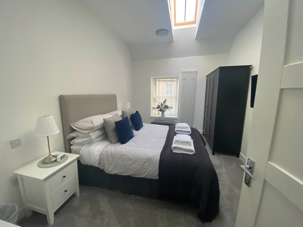 A bedroom with a bed and nightstand at The Old Barn in Manchester