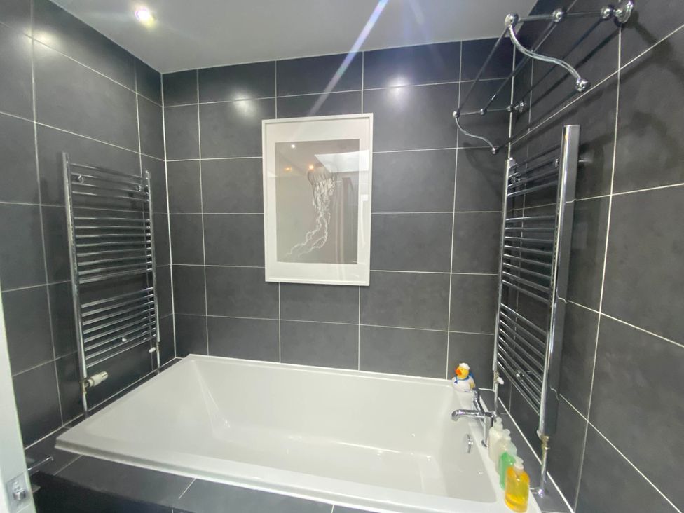 A bathroom featuring a bathtub and towel rails
