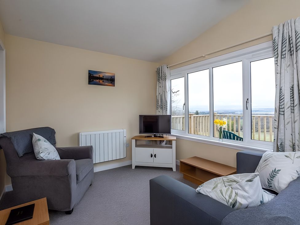 A living room with a sofa and television at Kilninver Chalet