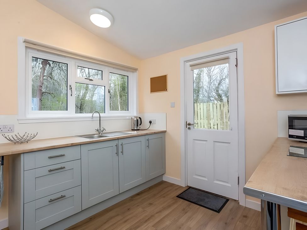 A kitchen with cabinets and a sink at Kilninver Chalet 