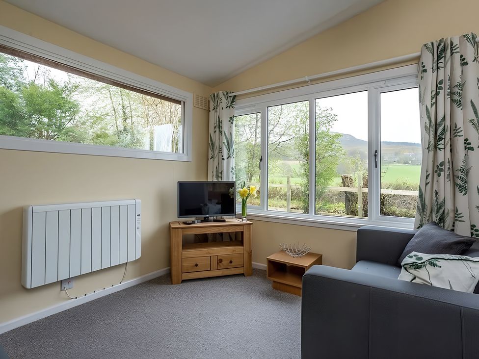 A living room with a sofa and television at The Old Barn in Manchester
