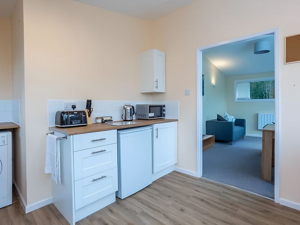 A kitchen with appliances and a view into a living area at the property