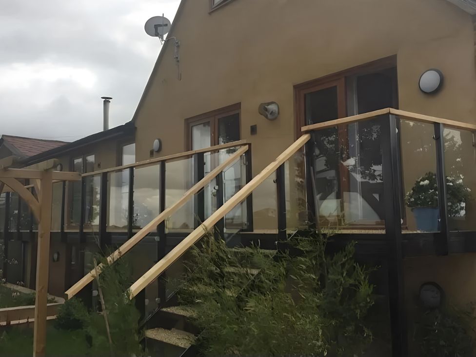 An outdoor area with a glass railing and stairs at Rutland Apartment