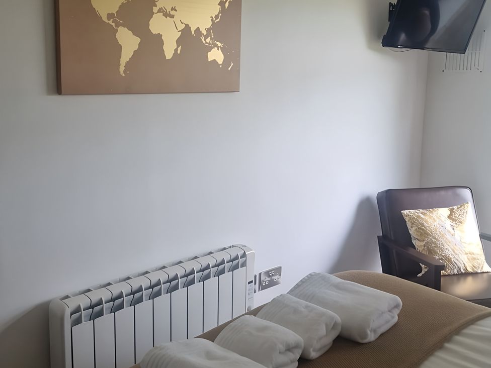 A bedroom with a world map and a chair at Rutland Apartment 
