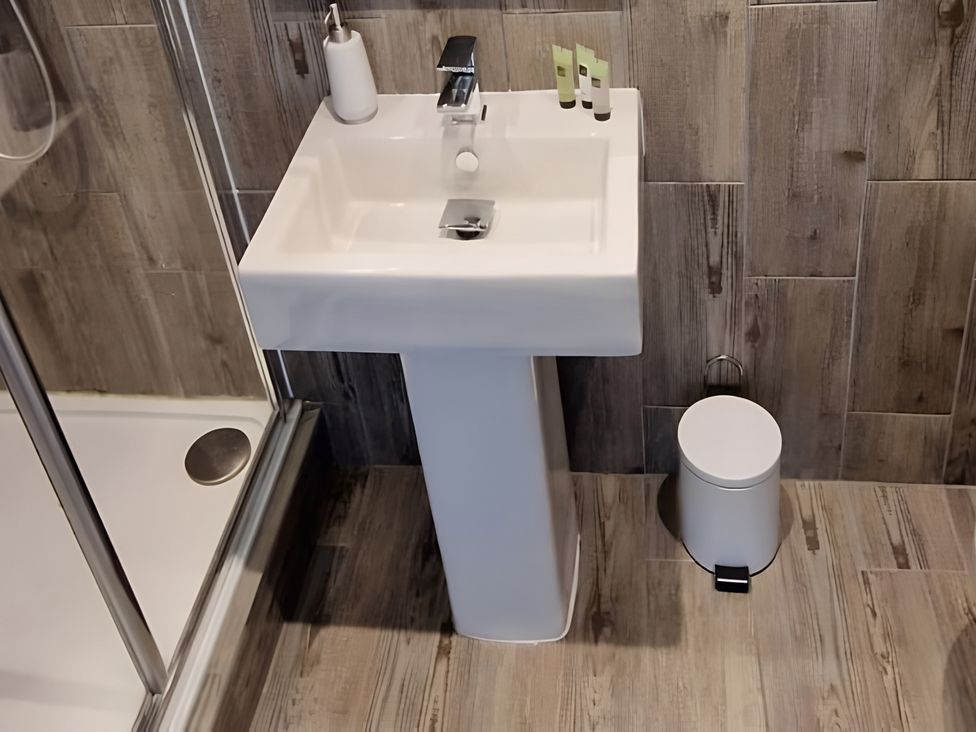 A wash basin with a faucet and toiletries in a bathroom at Rutland Apartment