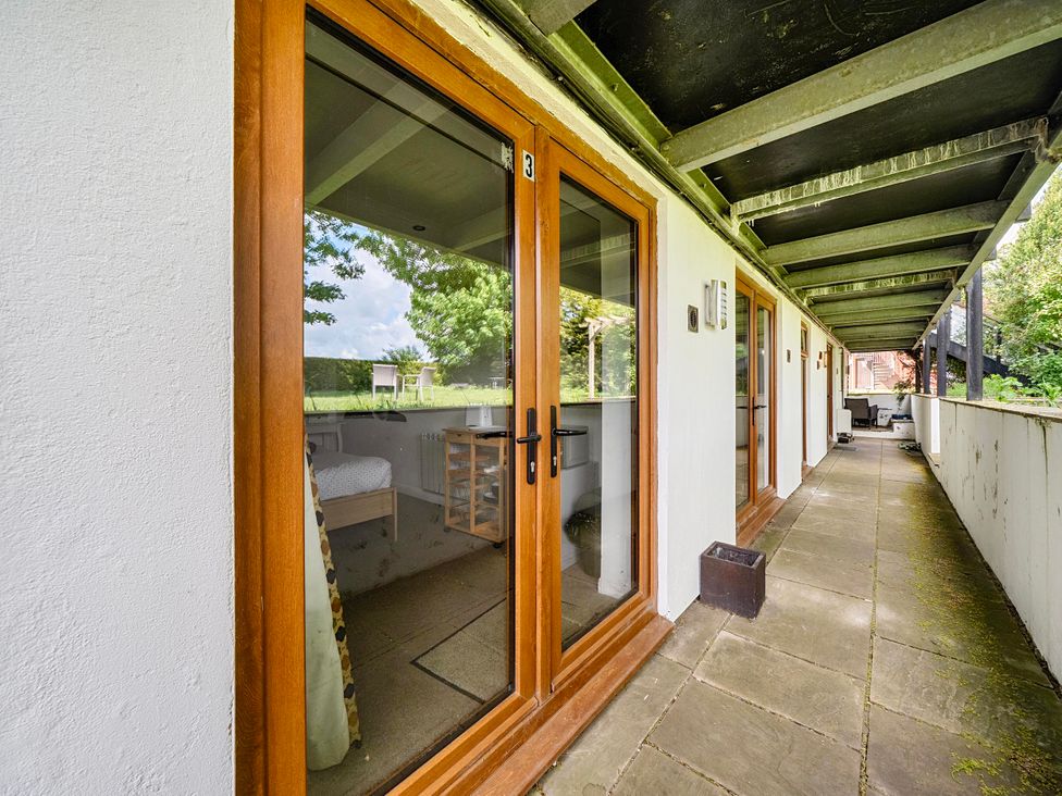 An outdoor area with glass doors and pathway at Rutland Apartment in Morcott