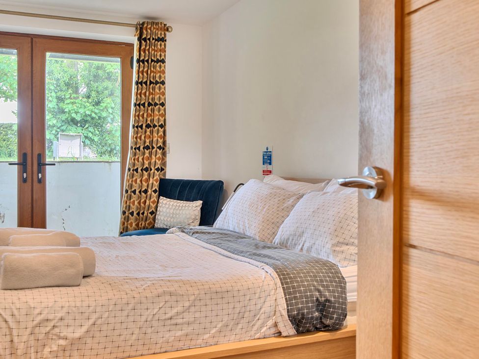 A bedroom with a bed and large window at Rutland Apartment in Morcott