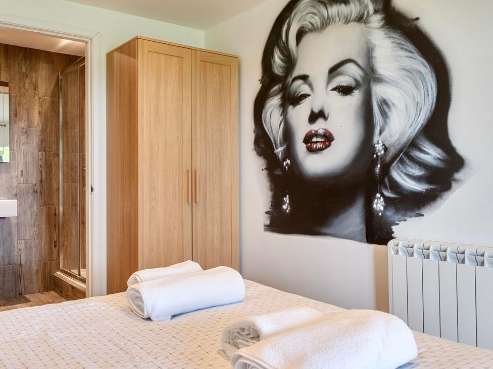 A bedroom with towels and a wardrobe at Rutland Apartment in Morcott