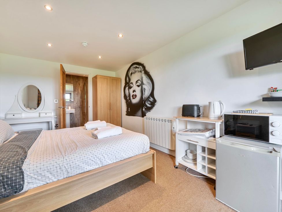 A bedroom with a bed and appliances at Rutland Apartment in Morcott
