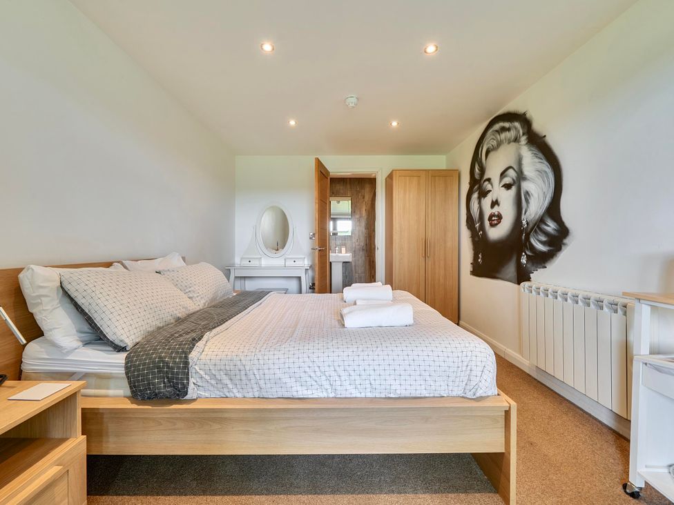 A bedroom with a bed and dresser at Rutland Apartment in Morcott