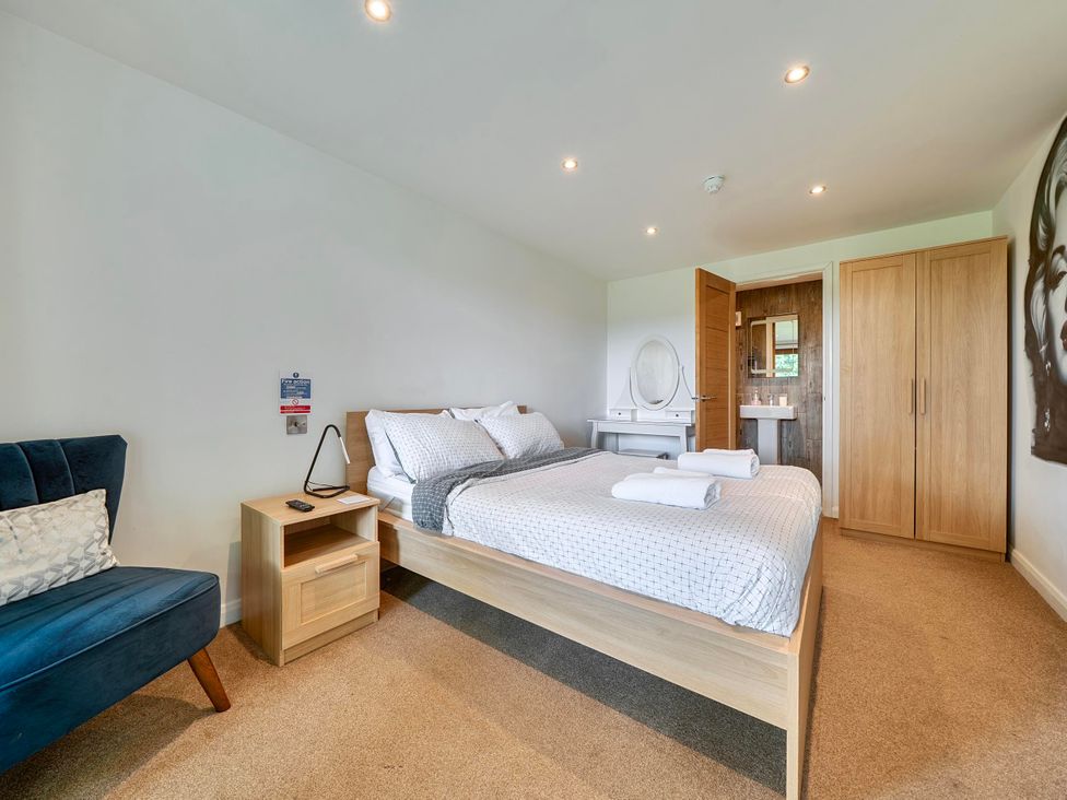 A bedroom with a double bed and a vanity at Rutland Apartment in Morcott