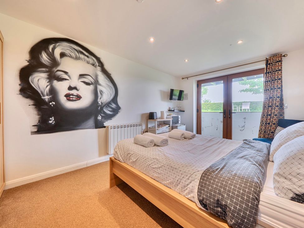 A bedroom with bed and wall art at Rutland Apartment in Morcott