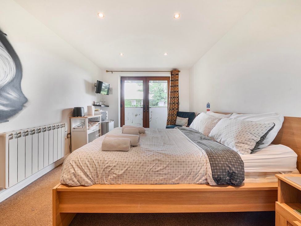 A bedroom with a bed and television at Rutland Apartment in Morcott