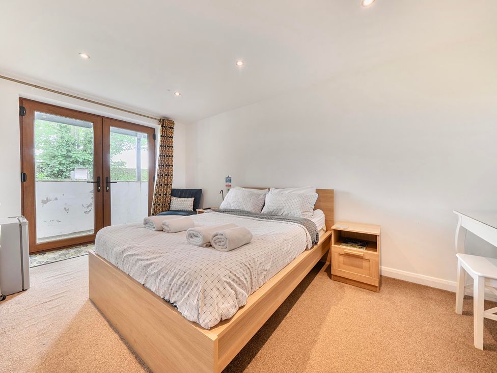 A bedroom with a bed and nightstand at Rutland Apartment in Morcott