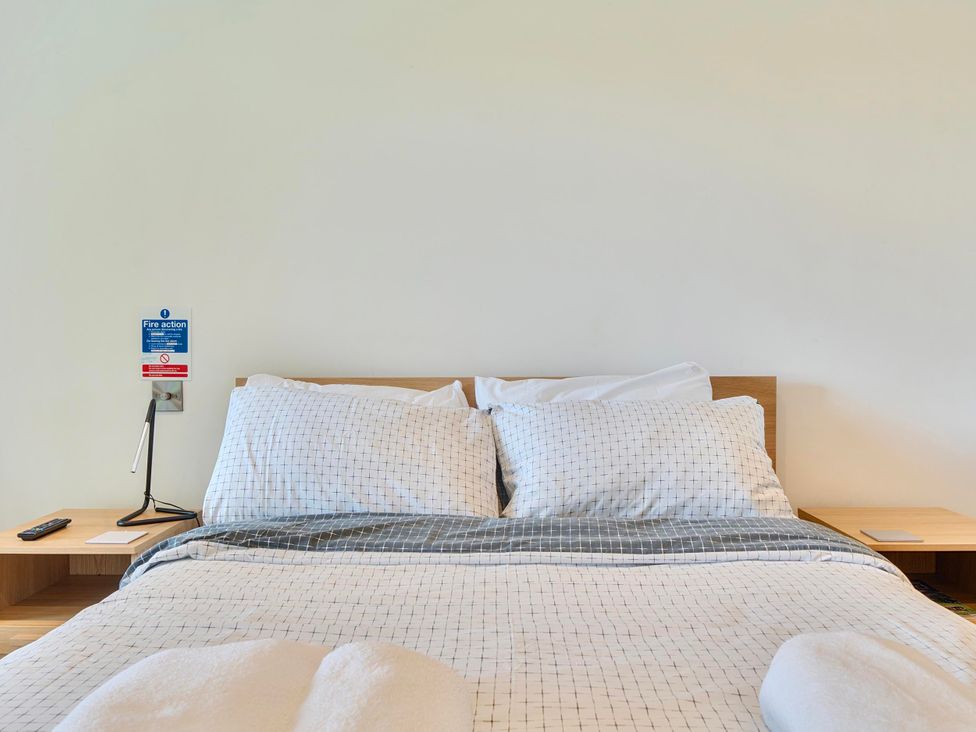 A bedroom with a bed and bedside table at Rutland Apartment in Morcott