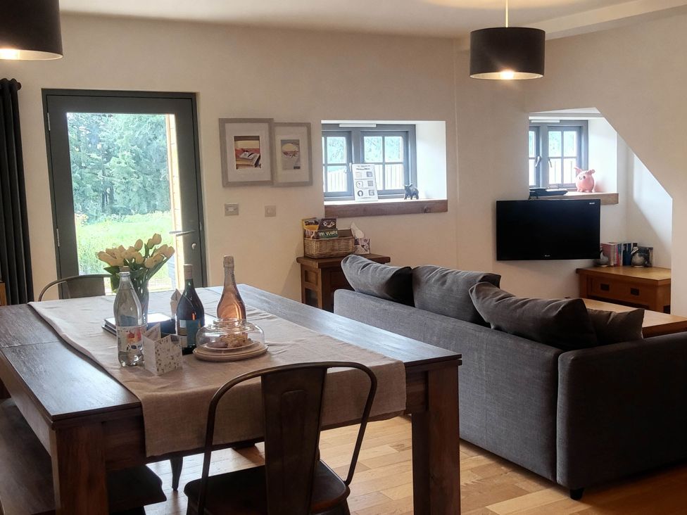 A living room with a couch and dining table at Old Highwood Barns Dunkeswell