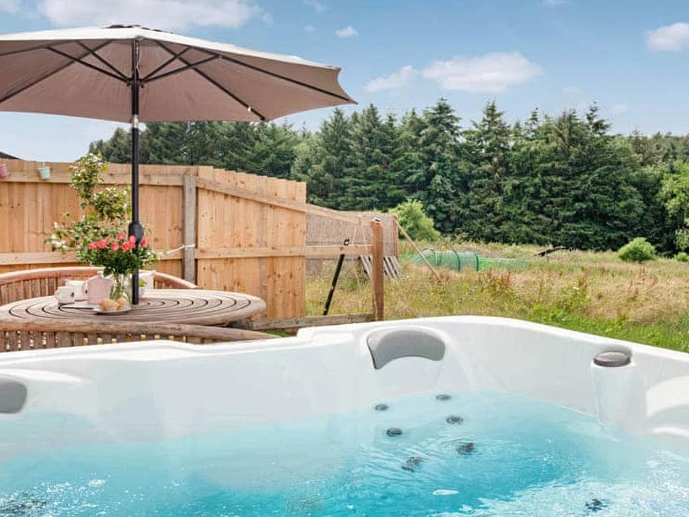 An outdoor patio with a hot tub and table at an unspecified location