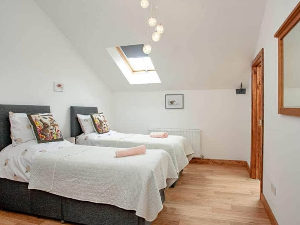 A bedroom with two beds and a skylight at The Old Barn in Manchester