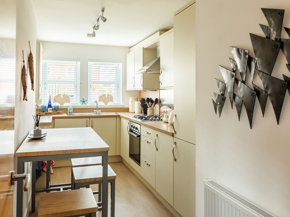 A kitchen with cabinets and a stove at Wee Jules By The Sea