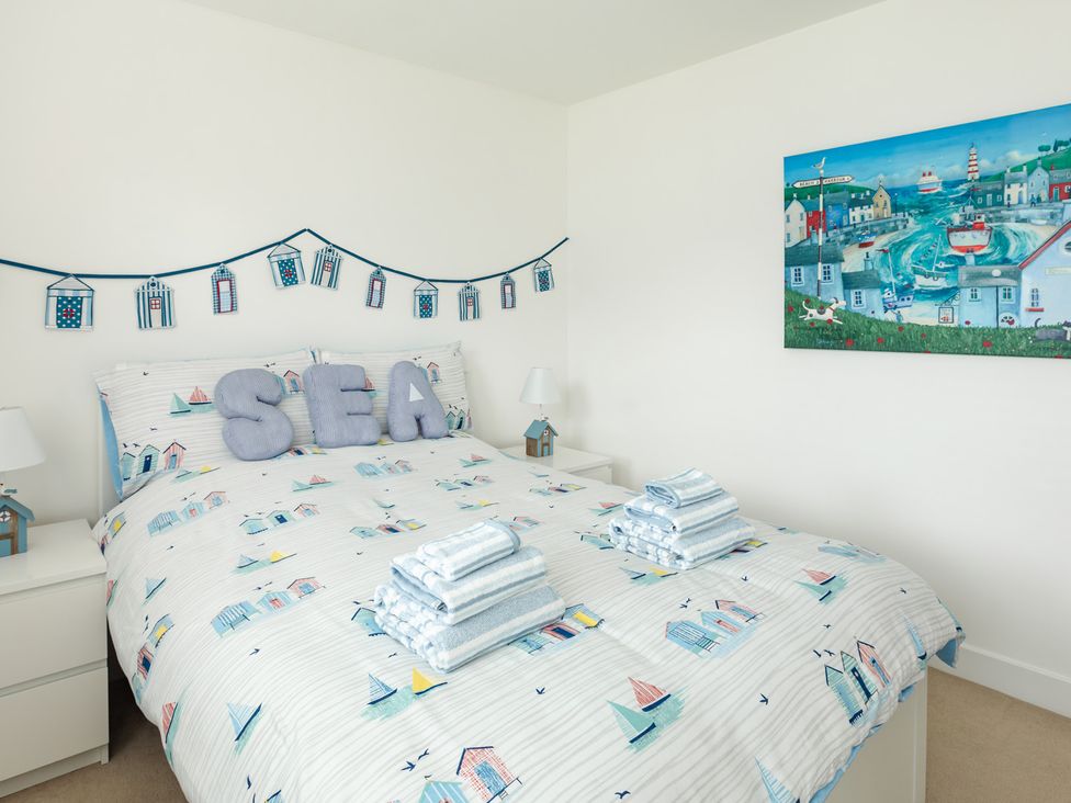 A bedroom with a bed and decorative wall art at Wee Jules By The Sea