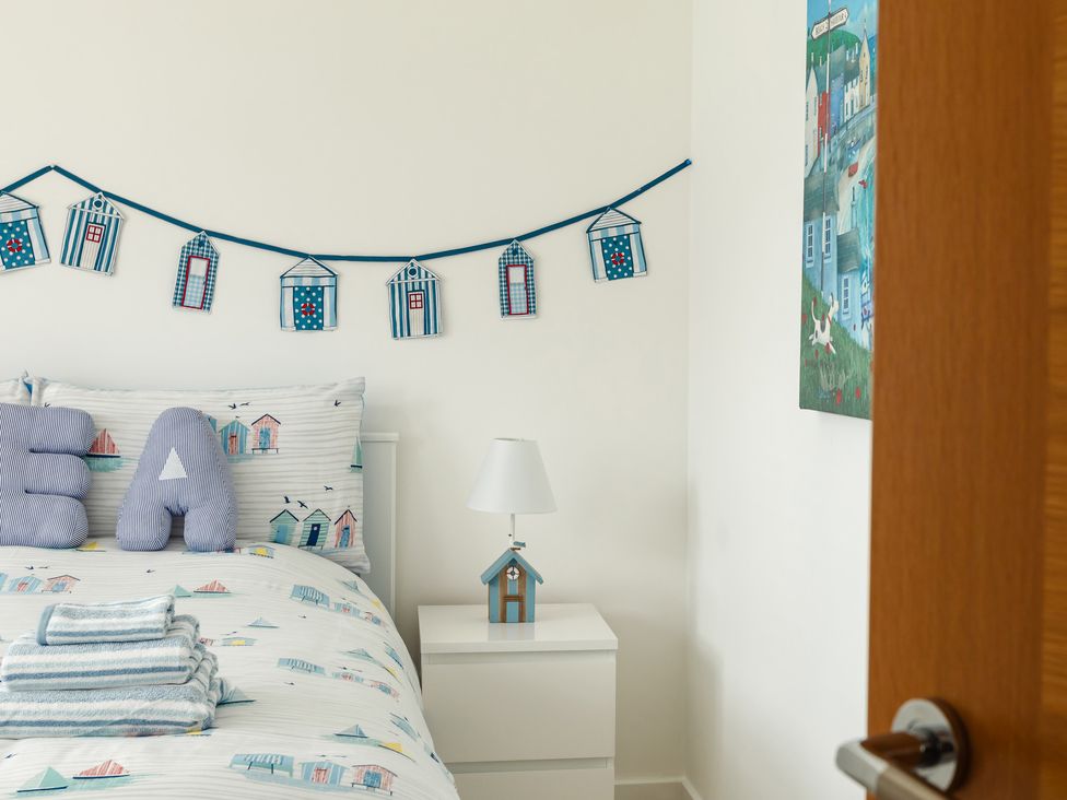 A bedroom with a bed and decorative items at Wee Jules By The Sea